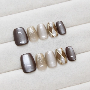 Handmade cat eye press-on nails with brown checkerboard patterns and gold glitter