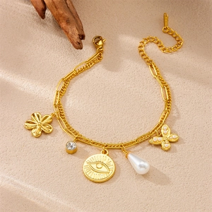 Détail d'un bracelet doré multi-breloques avec pendentifs fleurs, perles et papillons