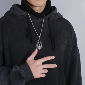 Detailed view of silver titanium angel wing skull pendant worn by male model