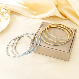 Detail of multi-stackable 3mm colorful enamel stainless steel bangles in gold and silver
