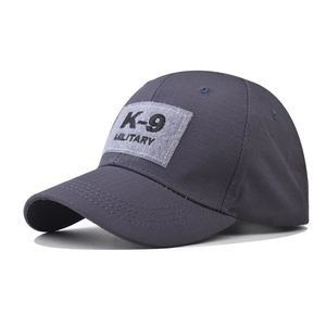 Detail of K-9 military embroidery on dark grey checkered fabric baseball cap