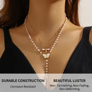 Close-up of double layer gold necklace with white bee and butterfly charms on model