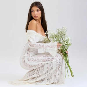 Detailed close-up of white lace flared sleeves and off-shoulder neckline on maxi dress