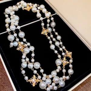Elegant multi-layer pearl necklace with gold cross pendant and rhinestones on black velvet
