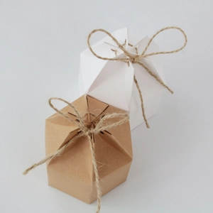 Macro shot of white and kraft hexagonal candy boxes with rustic twine bows