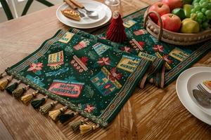 Detail of Christmas table runner with green tassels, woven pine and flower patterns