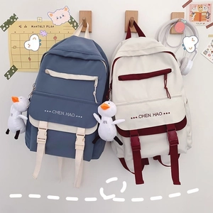 Detail of high-density canvas backpack featuring front buckle straps and a cute duck pendant
