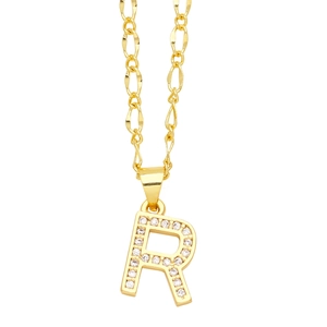 Macro shot of gold-plated letter R pendant with sparkling zircons and Figaro chain