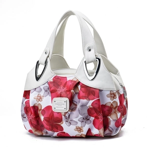 Detail view of floral patterned handbag with brown flower print and white leather straps