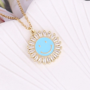 Macro detail of gold sunburst pendant with blue enamel smiley face and zircon inlay