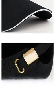 Detail of black cotton baseball cap showing white brim edge and adjustable bronze buckle