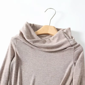 Detailansicht des aprikosenfarbenen Strickoberteils mit elegantem plissiertem Ausschnitt