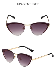 Detail view of cat eye sunglasses with gradient grey lenses and golden metal temples
