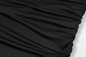 Detail of elegant black dress showing high-quality ruched fabric and fine texture