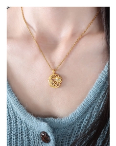 Close-up of golden sun and moon pendant necklace with crystal on model neck