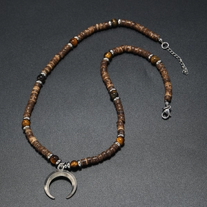 Close-up of vintage crescent moon pendant with brown coconut shell beads and tiger eye stones