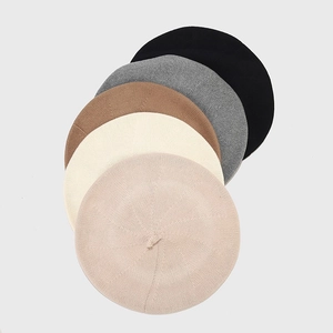 Detailed close-up showing knit texture of beret hats in black grey beige and pink