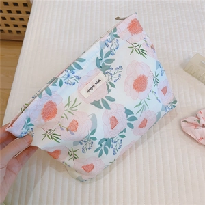 Close-up of floral cotton makeup bag with pink flower prints and a small label on it
