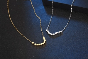 Detail view of gold and silver titanium steel necklaces with cubic link design