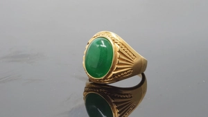 Detailed close-up of a gold-plated men's ring featuring a green oval stone inlay