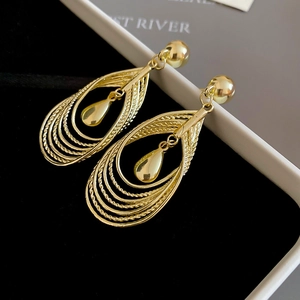 Macro shot of layered hollow teardrop earrings in gold finish with twisted rope texture
