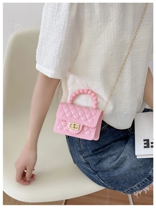Pink quilted jelly bag featuring a unique beaded handle and gold chain shoulder strap