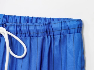Detail of blue striped trousers with elastic waist and white cotton drawstring