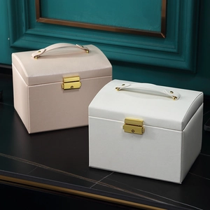 Detailed view of luxury leather jewelry boxes in cream and pink with gold metal locks