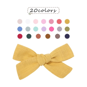 Detail view of yellow linen bow hair clip with 20 color options shown on a white background