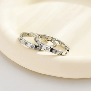 Detailed close-up of heart-shaped silver earrings with sparkling white diamonds on a tray