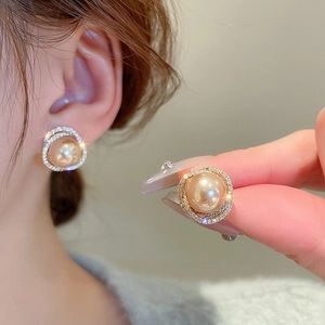 Gros plan de boucles d'oreilles perles dorées avec détails en strass brillants