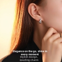 Silver geometric huggie earring with pink shell inlay on a female model's ear