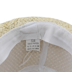 Detail view of woven straw hat interior featuring the size 58 and 100% paper material label