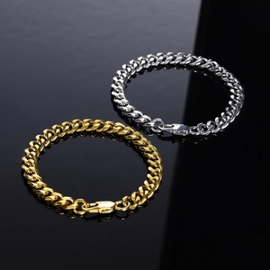 Close-up of gold and silver stainless steel Cuban link chains on a black reflective surface