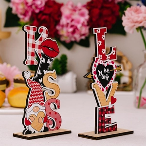 Close-up of wooden KISS and LOVE Valentine ornaments with heart and gnome details