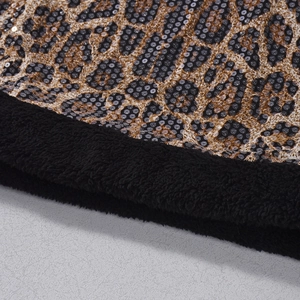 Macro-detail van luipaardprint stof met lovertjes en zwarte pluche bontrand