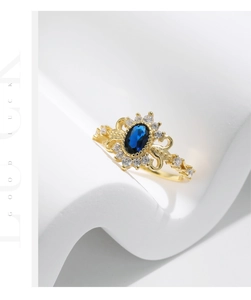 Macro detail of retro gold ring with oval blue gemstone and zircon halo setting