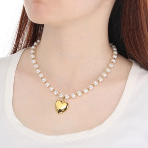 Close-up of pearl beaded heart pendant necklace with OT toggle clasp on model neck