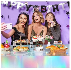 Holographic party tablecloth detail showing vibrant rainbow reflections in a birthday setup