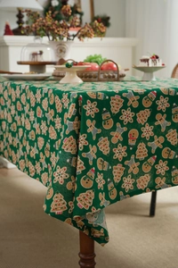 Detail of Christmas gingerbread man print on green cotton linen festive tablecloth
