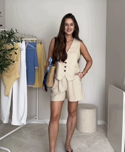 Detailed full-body view of women's beige linen set featuring a V-neck vest and loose shorts
