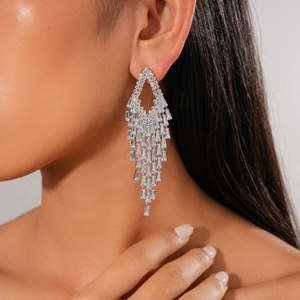 Close-up of geometric zircon fringe chandelier earrings on model in silver finish