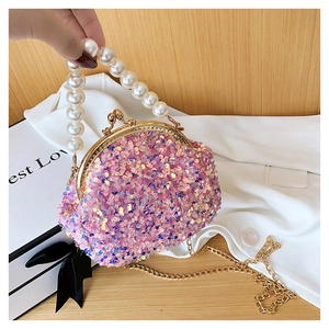 Close-up of pink sequined mini round bag with pearl handle and golden chain strap