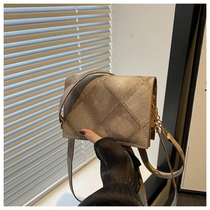 Dettaglio borsa trapuntata oro metallizzato con trama a rombi e catena elegante