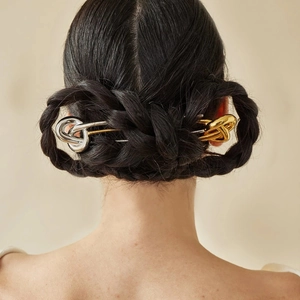 Polished stainless steel knot hairpins in gold and silver finish on braided hair