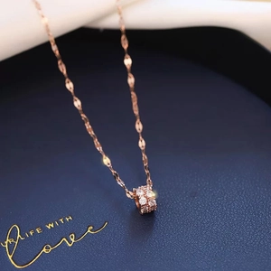 Detailed view of a rose gold small waist pendant necklace with zircons on blue backdrop