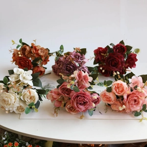 Detailed view of six vintage silk rose bouquets in various colors on a white table