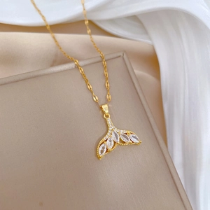 Elegant gold titanium fishtail necklace with clear zircon on beige display stand