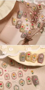 Macro detail of vintage floral nail art stickers with embossed roses and gold borders