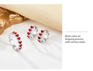 Macro shot of S925 silver ring and earrings with red oil dripping heart patterns